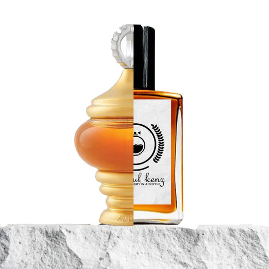 "Two contrasting perfume bottles side by side on a white surface."
 "On the left, a spherical-shaped orange and gold-colored perfume bottle of Alf Lail O Lail by Ajmal."
 "On the right, an amber-colored bottle of the Baytulkenz-inspired version of Ajmal Alf Lail O Lail."
 "The two bottles are positioned next to each other, showcasing their distinct shapes and colors."
 "The white surface beneath the bottles enhances their contrasting designs and vibrant colors."