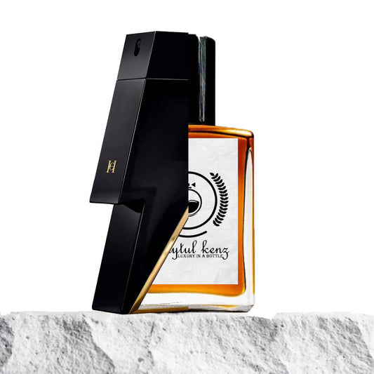 "A stylish image features two perfume bottles displayed side by side on a stone surface."
"On the left, a sleek black bottle with a unique angular design, representing Bad Boy by Carolina Herrera."
"The black bottle has a bold, modern shape and showcases a luxurious label with refined detailing."
"On the right, an amber-colored rectangular bottle, the Baytulkenz inspired version of Bad Boy by Carolina Herrera."
"The amber bottle features a clean, rectangular shape with a simple, 
 and elegant design." 