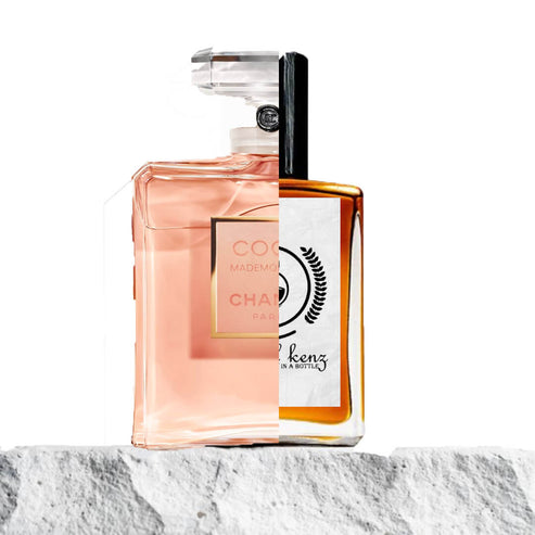 The image shows a creative split design featuring two perfume bottles from distinct brands. One side appears to represent Coco Mademoiselle by Chanel, which is known for its elegant and minimalistic design with a peachy-pink tone. The right side represents Baytulkenz Perfumes, displaying a warm amber liquid and a white label with the Baytulkenz logo and branding. Both bottles are set against a stone-textured surface, providing a striking juxtaposition of the two perfumes' distinct styles.