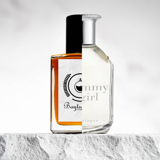 "Two bottles of perfume on a textured surface."
"On the left, an orange-colored bottle with a white label represents the Baytulkenz inspired version of "Tommy Girl" by Tommy Hilfiger."
"On the right, a white bottle with the label reading "Tommy Girl" by Tommy Hilfiger."
"The orange bottle has a bright, vibrant hue, while the white bottle features a classic and clean design."