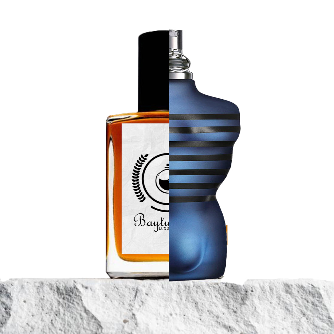 "Two perfume bottles merged on a stone surface, showcasing their contrasting designs."
"On the left, a half-classic clear glass bottle with amber-colored liquid representing the Baytulkenz inspired version of "Ultra Male Jean Paul Gaultier."
"On the right, a modern blue-designed bottle labeled "Ultra Male Jean Paul Gaultier."
"The amber bottle offers a warm, rich hue, while the blue bottle contrasts with a sleek and contemporary design."