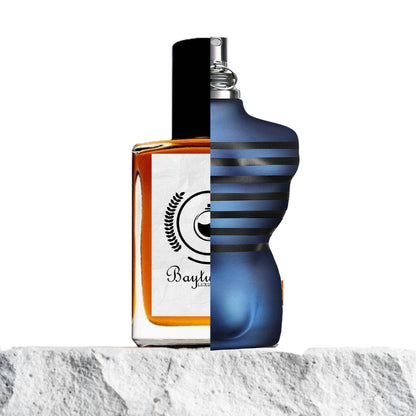 "Two perfume bottles merged on a stone surface, showcasing their contrasting designs."
"On the left, a half-classic clear glass bottle with amber-colored liquid representing the Baytulkenz inspired version of "Ultra Male Jean Paul Gaultier."
"On the right, a modern blue-designed bottle labeled "Ultra Male Jean Paul Gaultier."
"The amber bottle offers a warm, rich hue, while the blue bottle contrasts with a sleek and contemporary design."