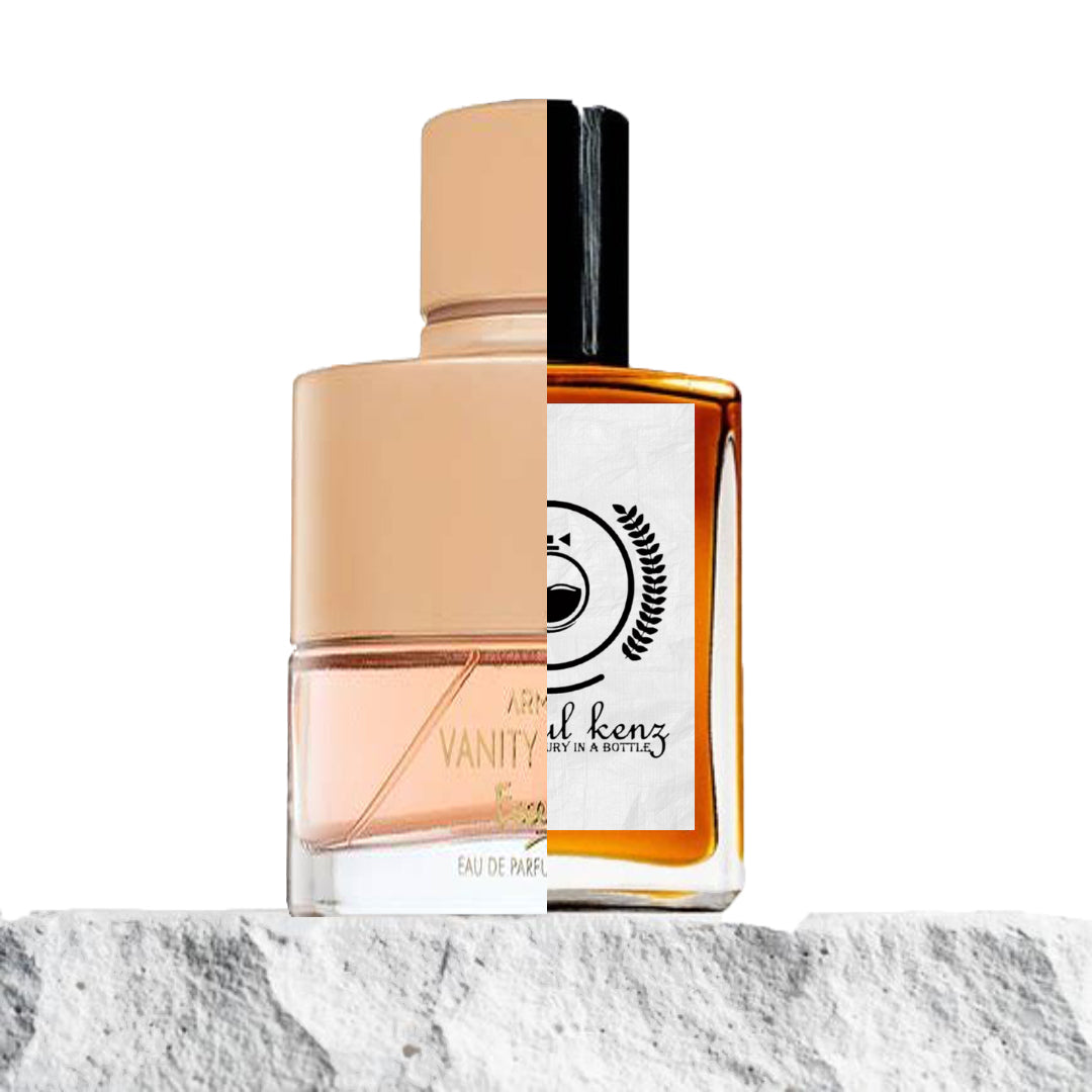 "Two perfume bottles placed on a white surface with a neutral background."
"On the left, a pink-colored bottle with a label reading "Vanity Femme Armaf."
"On the right, an amber-colored bottle with a white label representing the Baytulkenz inspired version of "Vanity Femme Armaf."
"The pink bottle features a soft and delicate appearance, while the amber bottle exudes a warmer, more earthy tone."