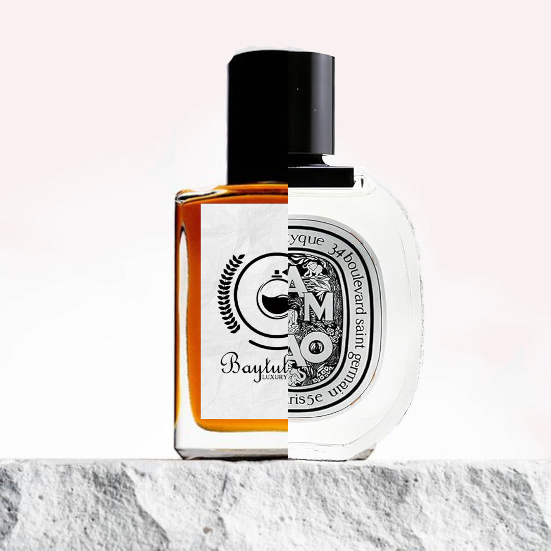 "Two perfume bottles are placed on a textured surface."
"On the left, an amber-colored bottle represents the Baytulkenz inspired version of "Tam Dao Diptyque."
"On the right, a clear white-colored bottle is labeled "Tam Dao Diptyque," showcasing a minimalist and elegant design."
"The amber bottle contrasts with the transparent, light-colored bottle, highlighting their differences in hue and design."